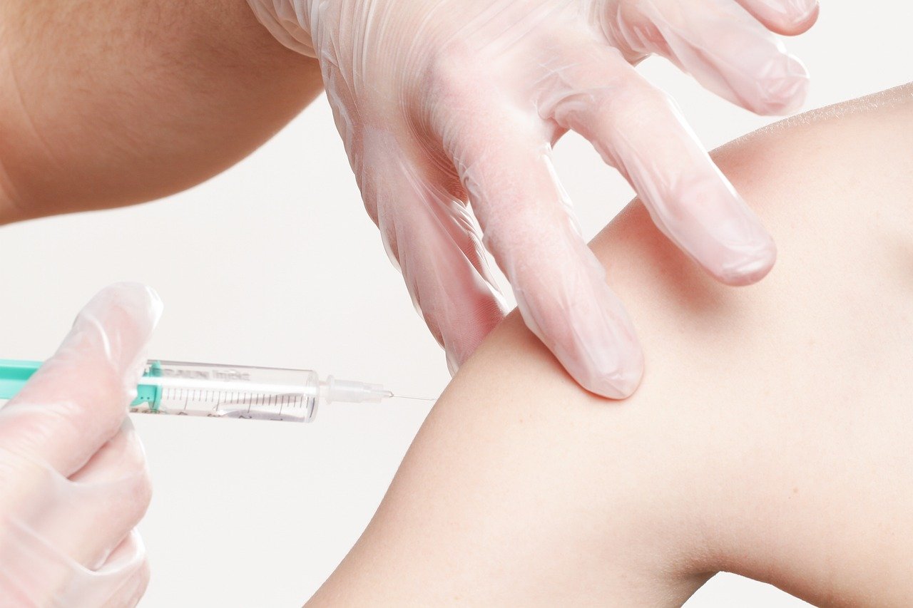 A healthcare professional giving a cartilage and steroid injection to a patient during a consultation